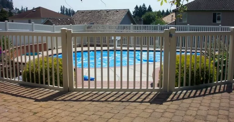 A beige metal fence built around a pool to provide protection