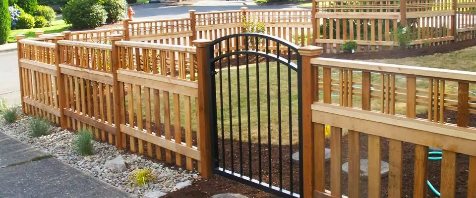 Small wooden front yard fence with wrought iron gate to illustrate residential fencing options