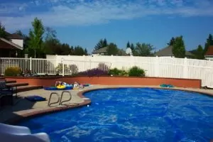 White vinyl fence behind a swimming pool