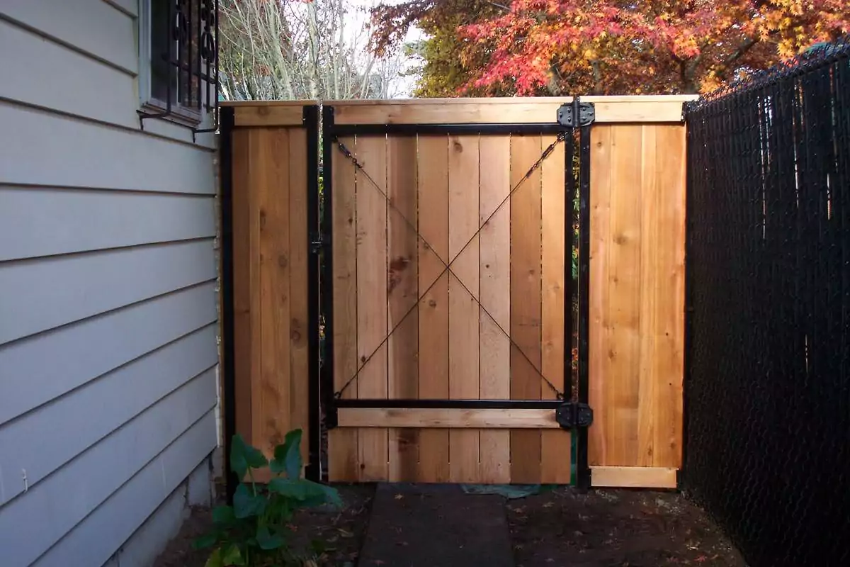 A new cedar fence gate with black metal posts and bracing.