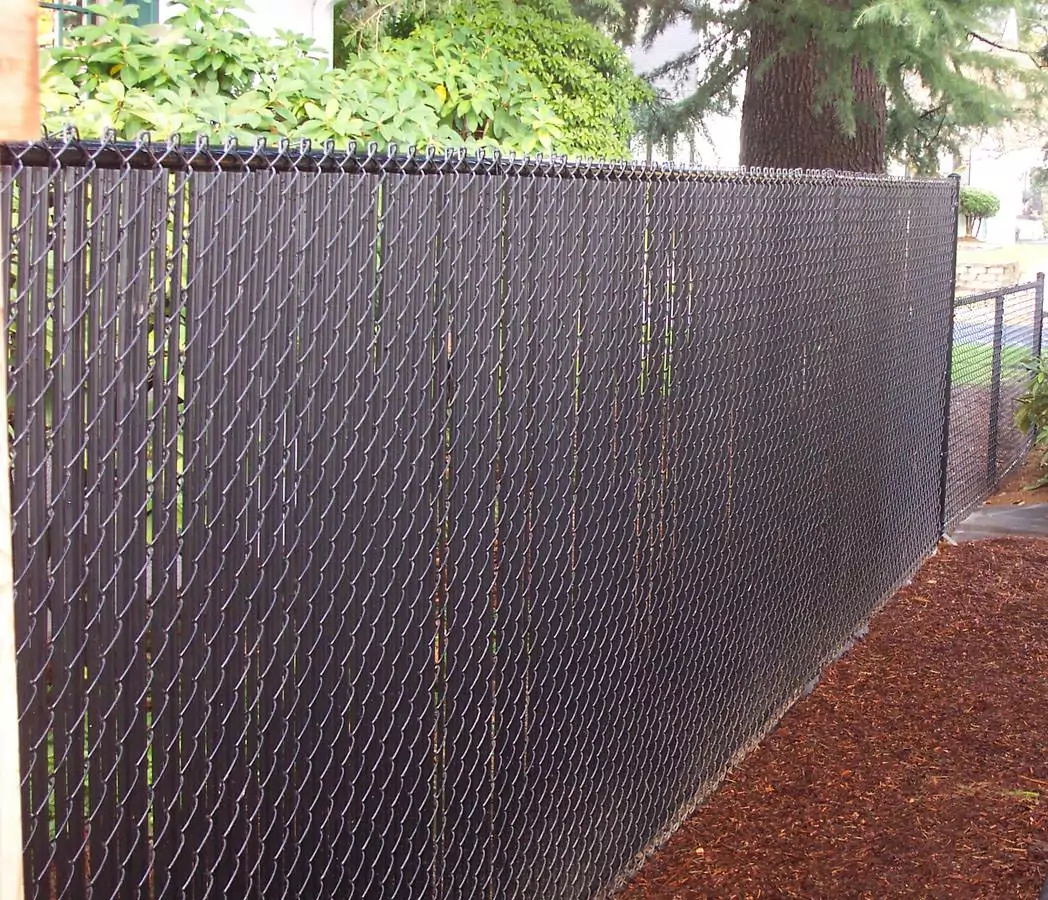 chain link fence with brown slats to help illustrate types of residential fences.