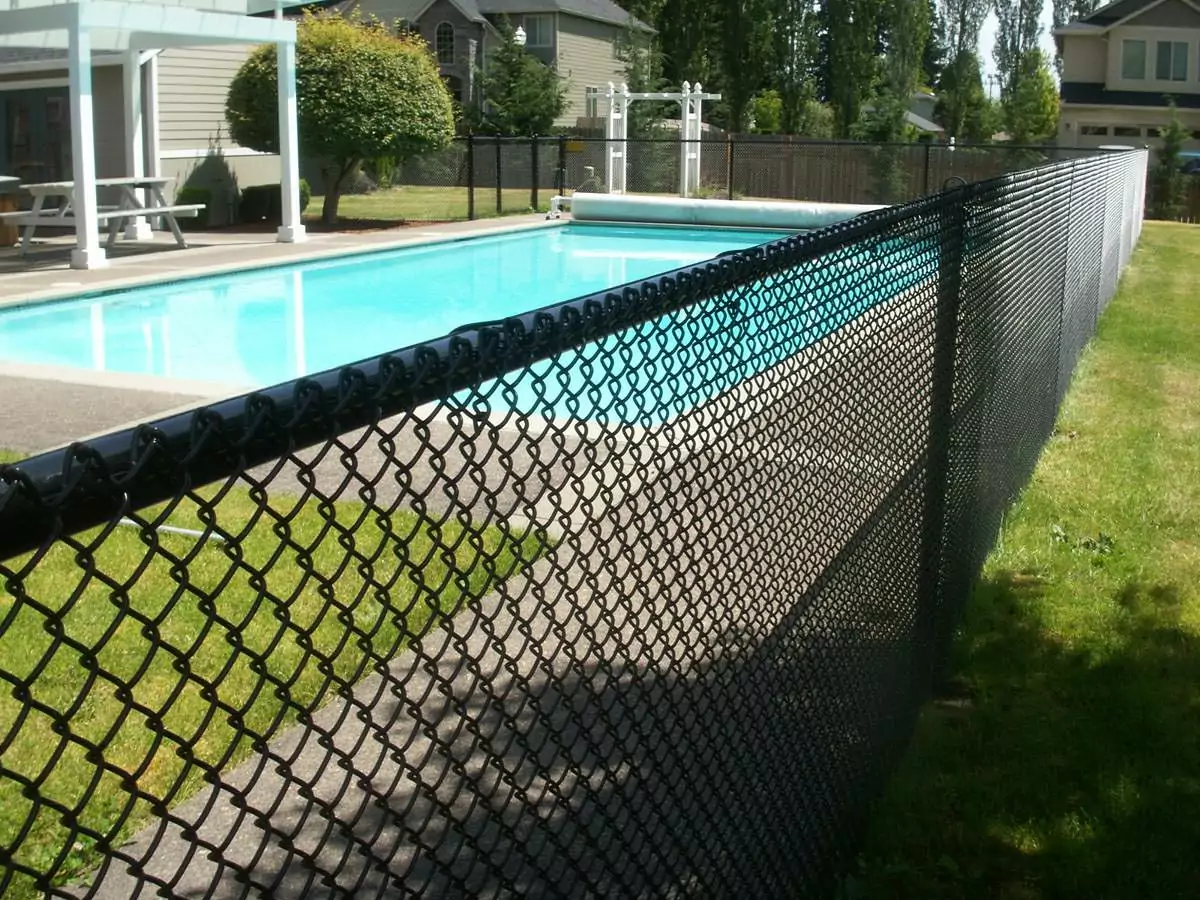 A black coated chin link pool fence around a nice, clean pool.