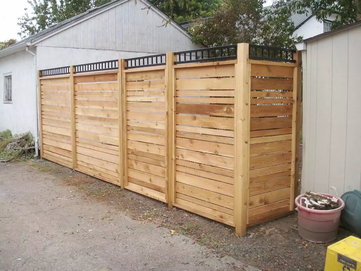 Wood fence with black lattice at the top and slats going side to side to help illustrate Affordable curb appeal.