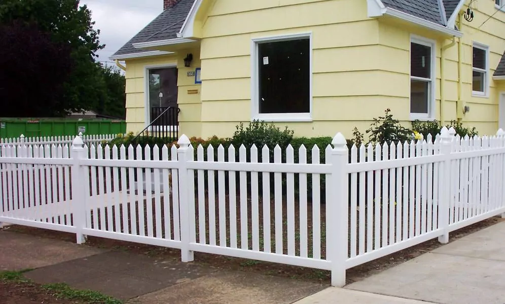 Cute yellow home on a corner with a picket fence to illustrate fence ideas for corner house.